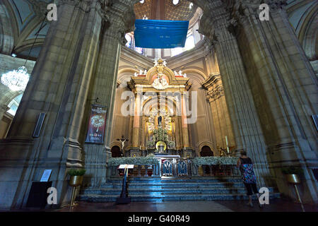 Der Hauptaltar und eine Person, die Ehrfurcht und Verehrung für die Muttergottes in der Wallfahrtskirche von Sameiro in Braga, Portugal Stockfoto