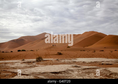 Sossusvlei-Landschaft mit Bergsteigern am Rand des Big Daddy Düne im Vordergrund in Namibia Stockfoto