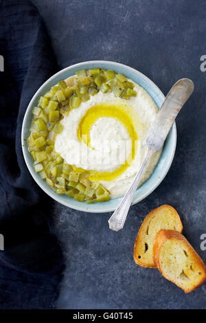 Geröstete Anaheim Pfeffer Manchego Pesto mit Crostini, in Keramikschalen auf dunklen grau/schwarz geschmolzenes Hintergrund, launisch. Fotografierten fr Stockfoto