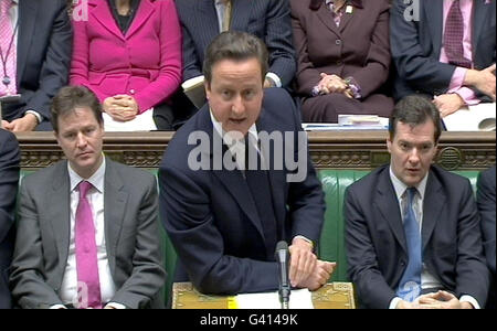 Premierminister David Cameron spricht während der Fragen des Premierministers, während der stellvertretende Premierminister Nick Clegg (links) und Bundeskanzler George Osborne (rechts) im Unterhaus in London nachschauen. Stockfoto