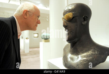 Chris Ingram posiert mit der Skulptur Goggle Head, 1969, von Elisabeth Frink, während der Pressevorschau für eine bevorstehende Ausstellung der Ingram Collection of 20th Century British Art in Sotheby's, London. Stockfoto