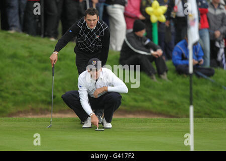 Golf - 38. Ryder Cup - Europa - USA - Tag 3 - Celtic Manor Resort. Europas Martin Kaymer (hinten) und Ian Poulter führen einen Putt an Stockfoto