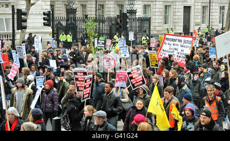 Eine Gruppe von Studenten geht an der Vorderseite der Downing Street (Tore im Hintergrund) vorbei, vor einer Demo gegen Bildungskürzungen der Regierung, bevor sie an den Houses of Parliament im Zentrum von Westminster, London, vorbeigeht. Stockfoto