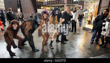 Die Besetzung der neuen Show des Cirque du Soleil, Totem, stellt Darwins ikonische Evolution der Menschenszene für Käufer und Büroangestellte an der Londoner Liverpool Street Station wieder her. Stockfoto