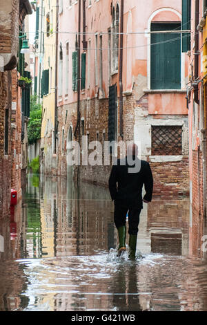 Venedig, Italien. 15. Juni 2016. Ein Mann mit Stiefeln geht zu Hause bei Hochwasser am 15. Juni 2016 in Venedig, Italien. Das Hochwasser in diesem Zeitraum ist außergewöhnlich, und es ist eine Überraschung für Bürger und Touristen.  Bildnachweis: Simone Padovani/Erwachen/Alamy Live-Nachrichten Stockfoto