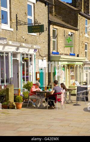 Menschen außerhalb Cafe sitzen. Cafe1618, 16 Marktplatz, Middleton-in-Teesdale, County Durham, England, Vereinigtes Königreich, Europa. Stockfoto