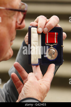 Raymond Morris zeigt stolz die Silberne Meer-Gallanterie-Medaille, die 35 posthum an seinen Stiefvater Robert Henry Treadwell im Alter von 1944 Jahren verliehen wurde. Morris und seine Familie spenden die Medaille an das Royal Navy Museum in Portsmouth. Stockfoto