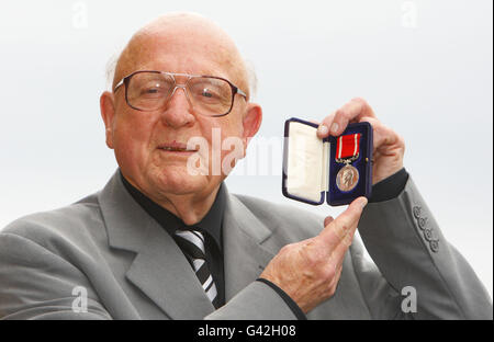 Raymond Morris zeigt stolz die Silberne Meer-Gallanterie-Medaille, die 35 posthum an seinen Stiefvater Robert Henry Treadwell im Alter von 1944 Jahren verliehen wurde. Morris und seine Familie spenden die Medaille an das Royal Navy Museum in Portsmouth. Stockfoto