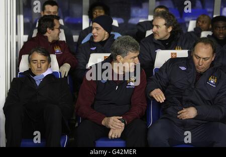 Manchester City Manager Roberto Mancini (links), Assistant Manager Brian Kidd und First Team Coach David Platt (rechts) auf der Bank Stockfoto