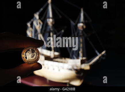 2 Münze zum 500. Jahrestag der Einführung der Mary Rose, wird vor einer Nachbildung des legendären Schiffes gehalten, im Mary Rose Museum in Portsmouth. Stockfoto