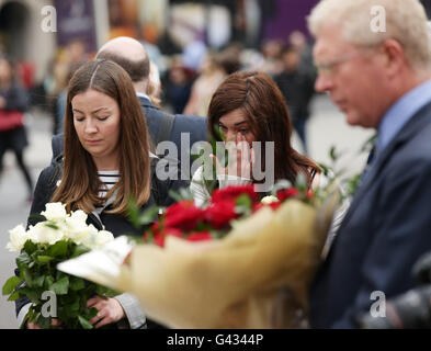 John Cryer MP (rechts) unter den Menschen betrachten floral Tribute in Parliament Square, London, nachdem Labour MP Jo Cox wurde erschossen und auf der Straße außerhalb ihrer Wahlkreis-Beratung-OP in Birstall, West Yorkshire erstochen. Stockfoto