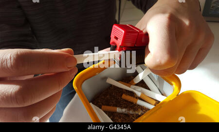 Rollende Maschine und Zigaretten Stockfoto