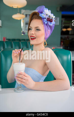 1960er Jahre aussehen Pin-up Girl in einem American Diner mit einem Milchshake Stockfoto