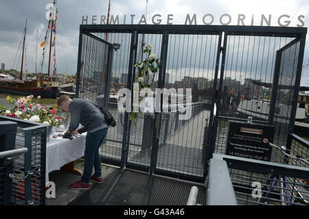 Ein Mann signiert ein Buch Kondolenzschreiben für Jo Cox am Hermitage Liegeplätze auf der Themse in London, wo die MP auf einem umgebauten Lastkahn, lebte, nachdem sie wurde erschossen und, außerhalb ihrer Wahlkreis-Beratung-OP erstochen. Stockfoto