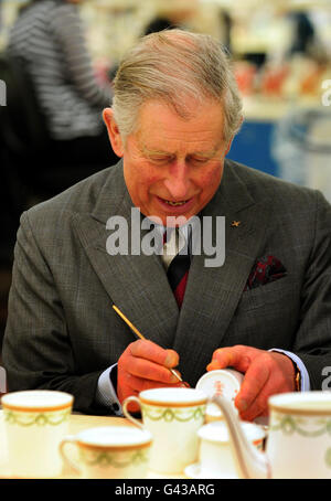 Prinz Charles vergoldet eine Tasse bei einem Besuch des Royal Crown Derby in Derby. Stockfoto