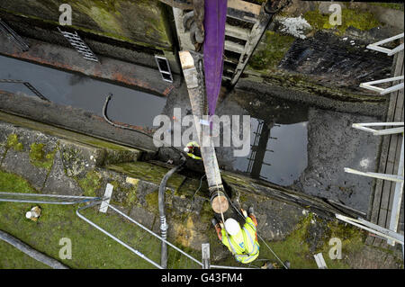 Arbeiter steady das drei Tonnen schwere Eichenschloss Nummer 39 in Position über dem Caen Hill Flight of Locks auf dem Kennet & Avon Kanal, in der Nähe von Devizes, Wiltshire. Stockfoto