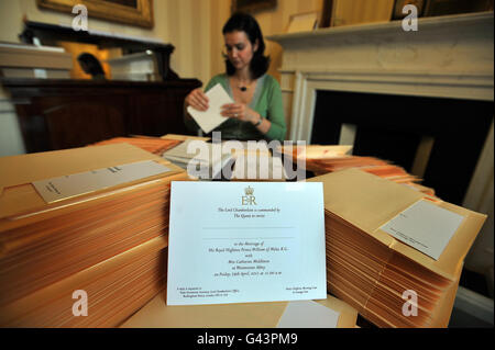 Ein Mitglied des Lord Chamberlain's Office (Name nicht angegeben) im Buckingham Palace in London legt die Einladungen zur Hochzeit von Prinz William und Kate Middleton in Umschläge ein, bevor sie an die glücklichen Gäste, die am 29. April in der Westminster Abbey anwesend sein werden, verschickt werden. Stockfoto