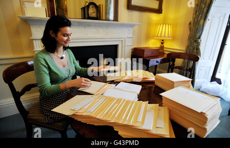 Ein Mitglied des Lord Chamberlain's Office (Name nicht angegeben) im Buckingham Palace in London legt die Einladungen zur Hochzeit von Prinz William und Kate Middleton in Umschläge ein, bevor sie an die glücklichen Gäste, die am 29. April in der Westminster Abbey anwesend sein werden, verschickt werden. Stockfoto