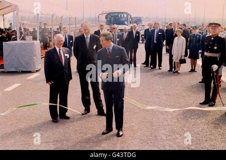 Bei strahlendem Sonnenschein und umgeben von Würdenträgern wie dem Verkehrsminister Sir George Young (zweite linke, vordere Gruppe) schneidet HRH der Prinz von Wales das Band auf der englischen Seite, um den zweiten Severn Crossing offiziell zu eröffnen. Stockfoto