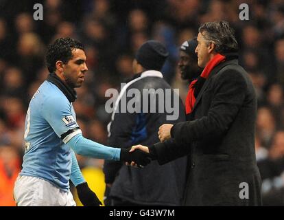 Fußball - Barclays Premier League - Manchester City / West Bromwich Albion - City of Manchester Stadium. Carlos Tevez von Manchester City schüttelt sich nach seiner Ersetzung die Hände seines Managers Roberto Mancini Stockfoto