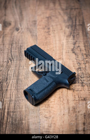 Eine halbautomatische Pistole der Sig P250 auf Holzuntergrund Stockfoto