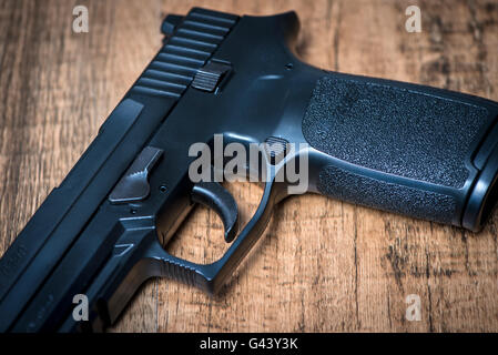 eine halbautomatische Pistole der Sig P250 auf Holzuntergrund Stockfoto