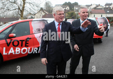 Labour-Chef Eamon Gilmore (links) kommt an der Carrick-on-Shannon Community School in Leitrim mit Roscommon/South Leitrim-Kandidat Ratsmitglied John Kelly an. Stockfoto