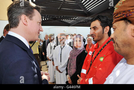 Der britische Premierminister David Cameron spricht mit einem BP-Mitarbeiter bei einer Veranstaltung bei BP in Muscat, Oman, zur offiziellen Einweihung der Extended Well Test Facility von BP Oman. Stockfoto