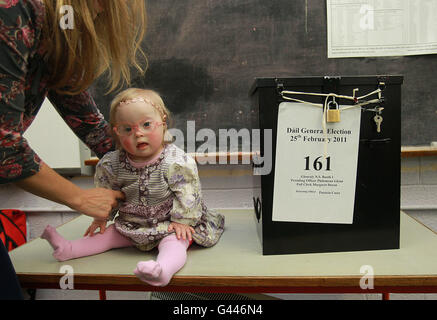 Die einjährige Rose Verveen wird von ihrer Mutter Viv Verveen abgeholt, nachdem sie bei den irischen Parlamentswahlen an der St. Joseph's National School in Glenealy, Co.Wicklow, ihre Stimme abgegeben hat. Stockfoto