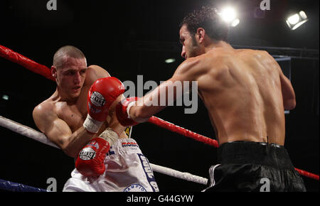 Stephen Foster (links) wird von Ermano Fegatilli beim EBU Super Featherweight Title Fight im Reebok Stadium, Bolton, an den Seilen gefangen. Stockfoto