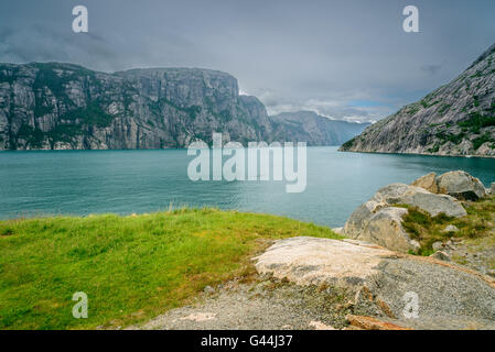 Blaues Wasser und Rocky Mountains am Ufer der Lysefjord, Norwegen Stockfoto