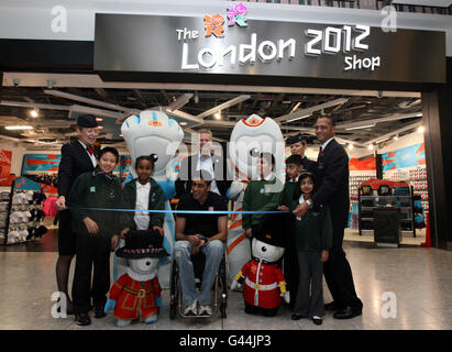 Paralympics-Athlet Mandip Sehmi (Mitte, vorne) mit LOCOG-Chef Paul Deighton (Mitte, hinten) mit London 2012 Maskottchen, Botschaftern von British Airways und Kindern der Cranford Primary School in Hounslow; Avrey Santos (mittlere Reihe, links), Samira Ali (mittlere Reihe, 2. Reihe links), Zain Malik (mittlere Reihe, 3. Reihe rechts), Royan Sal (mittlere Reihe, 2. Reihe rechts) und Gurleen Thind (mittlere Reihe, rechts) eröffnen den ersten offiziellen London 2012 Olympic Store im Terminal 5 am Flughafen Heathrow. Stockfoto