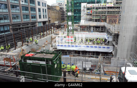 Mehr als 40 Bläser- und Schlagzeugmusiker der Guildhall School of Music and Drama führen auf dem Boden des neuen Konzertsaals der Schule, der derzeit im Milton Court in London entwickelt wird, einen "Hardhat Prom" auf. Stockfoto