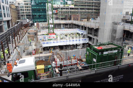 Mehr als 40 Bläser- und Schlagzeugmusiker der Guildhall School of Music and Drama führen auf dem Boden des neuen Konzertsaals der Schule, der derzeit im Milton Court in London entwickelt wird, einen "Hardhat Prom" auf. Stockfoto