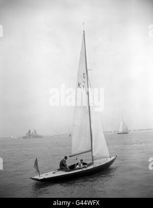 Der Herzog von Edinburgh (links) lehnt sich nach vorne, um am vierten Tag der Cowes Regatta Week die Deichsel der 'Dragon'-Yacht 'Bluebottle' zu ergreifen, die er gemeinsam mit der Queen besitzt. Begleitet wurde der Duke von der Yacht-Racing-Expertin Uffa Fox. Stockfoto