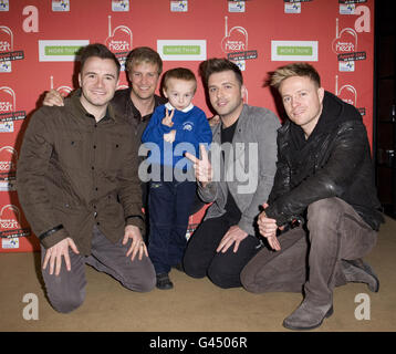 Shane Filan, Kian Egan, Mark Feehily und Nicky Byrne von Westlife im Bild mit Macauley Rogers, nachdem sie geholfen haben, über 3000 in Hilfe von Heart's zu sammeln, haben einen Herzanruf am Herzen, Global Radio Studios in London. Stockfoto