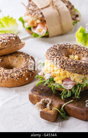 Leeren und streuen Samen Vollkorn Brötchen mit Rührei, Erbse sprießen, gebratenen Zwiebeln und Schinken, auf wh-Mitarbeiter Stockfoto