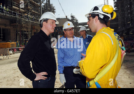Der britische Premierminister David Cameron (links) trifft den Sicherheitsmanager Talal Mehana (rechts) bei einem Besuch in Shell's riesiger neuer Gas-zu-Flüssigkeit-Anlage in Katar, bekannt als Pearl, mit Shell-Executive Vice President und Pearl-Chef Andy Brown. Stockfoto