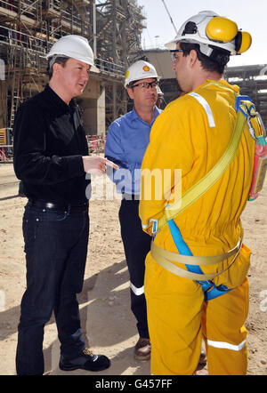 Der britische Premierminister David Cameron (links) trifft den Sicherheitsmanager Talal Mehana (rechts) bei einem Besuch in Shell's riesiger neuer Gas-zu-Flüssigkeit-Anlage in Katar, bekannt als Pearl, mit Shell-Executive Vice President und Pearl-Chef Andy Brown. Stockfoto