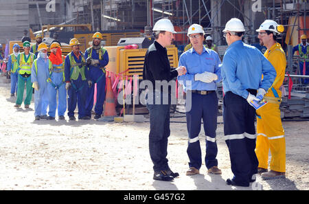 Der britische Premierminister David Cameron trifft den Sicherheitsmanager Talal Mehana (rechts) bei einem Besuch in Shell's riesiger neuer Gas-zu-Flüssigkeit-Anlage in Katar, bekannt als Pearl, mit Shell-Executive Vice President und Pearl-Chef Andy Brown (3. Rechts). Stockfoto