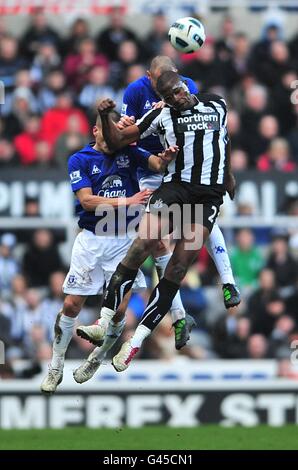 Shola Ameobi von Newcastle United kämpft um den Ball im Air mit Evertons Johnny Heitinga (hinten) und Leon Osman (links) Stockfoto