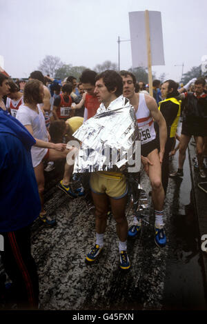 Die Teilnehmer halten sich warm und trocken, während sie den Star des ersten London-Marathons in Greenwich erwarten. Ein Teilnehmer trägt eine „Pace Blanket“ aus Aluminiumfolie, um sich warm zu halten, bevor er das 26 Meilen lange 385-Meter-Rennen bestiegen wird. Stockfoto