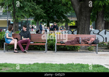 Ein Obdachloser auf einer Parkbank in Erzsébet Quadrat (Erzsébet Tér) schlafen. Der Platz ist die größte Grünfläche in Budapest Stockfoto