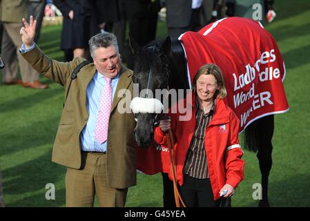 Trainer Paul Nicholls (links) feiert Big Bucks drittes Jahr in Folge als Rennsieger, nach dem Sieg in der Ladbrokes World Hurdle am St. Patrick's Day während des Cheltenham Festivals Stockfoto