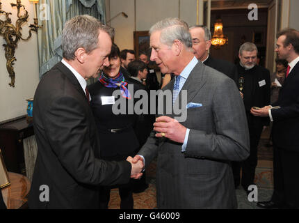 Prinz Charles trifft Frank Skinner (links), als er im Clarence House einen Empfang veranstaltet, um den 400. Jahrestag der King James Bible in London zu feiern. Stockfoto