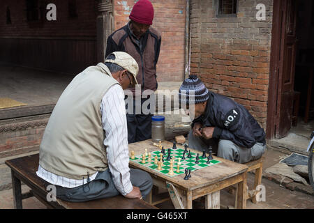 Bhaktapur, Nepal - 5. Dezember 2014: Ältere Männer spielen Schach in den Straßen. Stockfoto