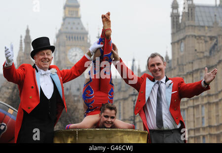 Der Contortionist Lorwi Thomas tritt heute vor dem Londoner Parlamentsgebäude mit dem Ringmeister Norman Barrett (links) auf, bevor der stellvertretende Sprecher des Repräsentantenhauses Nigel Evans (rechts) den Zirkusleuten die Möglichkeit gibt, sich mit Politikern zu treffen. Stockfoto