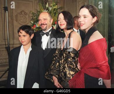 Anthony Minghella, Direktor des englischen Patienten, und seine Frau Carolyn Choa kommen mit ihrer Familie zur BAFTA-Preisverleihung in die Royal Albert Hall, London. Stockfoto