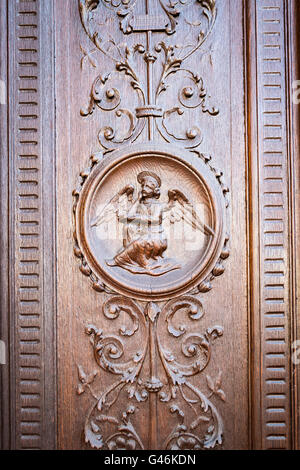 Engel eingraviert auf dem hölzernen Portal einer mittelalterlichen Kirche. Stockfoto