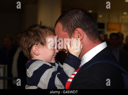 Cricket - Ankunft Des England-Teams - Flughafen Heathrow. Der Engländer Andrew Strauss kuschelt seinen Sohn Luca, als er am Londoner Flughafen Heathrow ankommt. Stockfoto